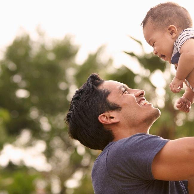 new-dad-with-baby-outdoors-playing